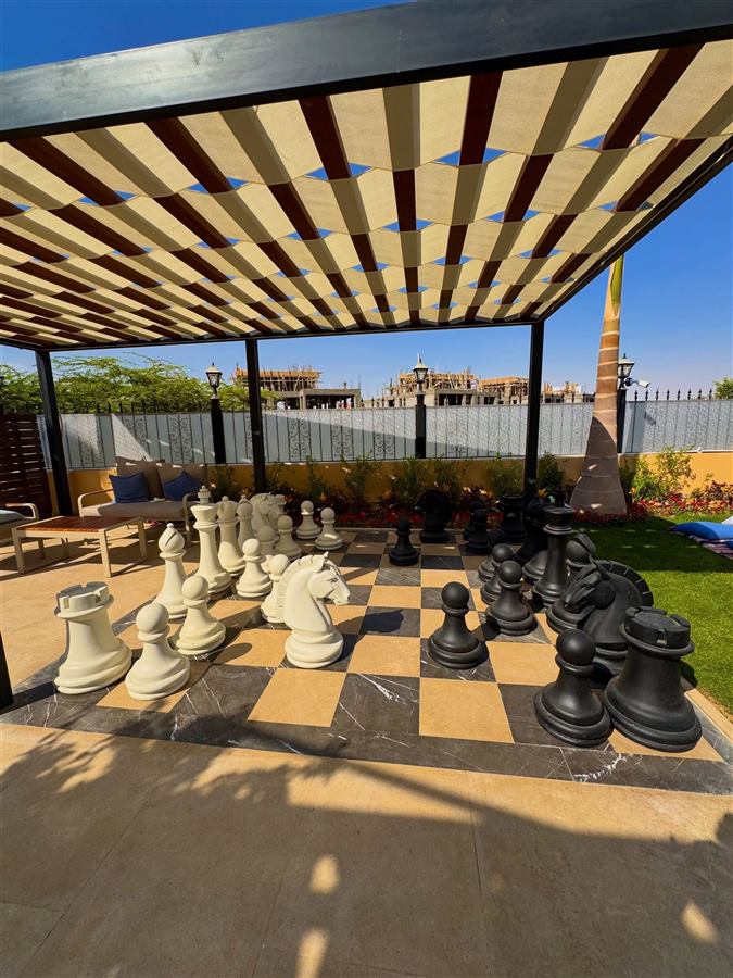 Giant chess set on a marble board under a pergola