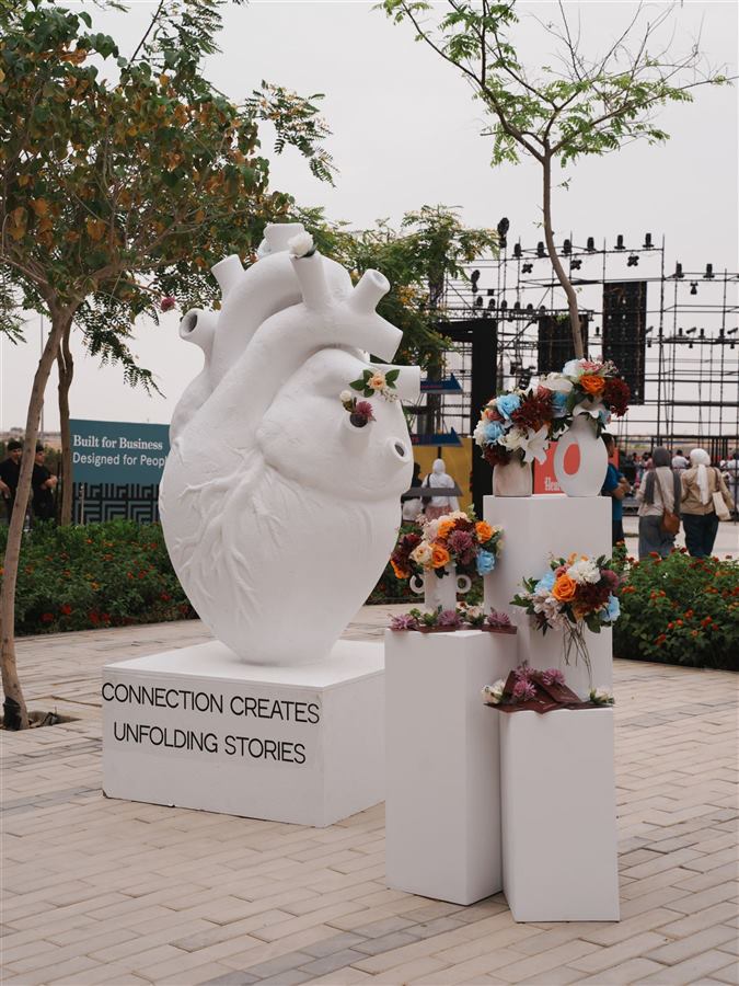 White anatomical heart sculpture with flowers at an evening event