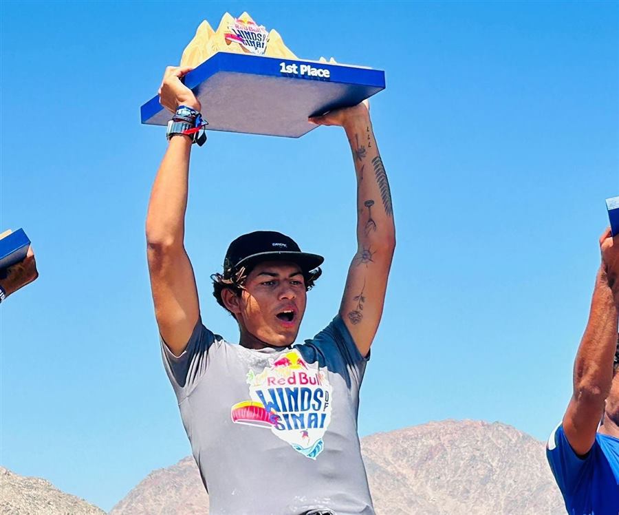 Athlete raising a sculpted mountain trophy at a Red Bull event